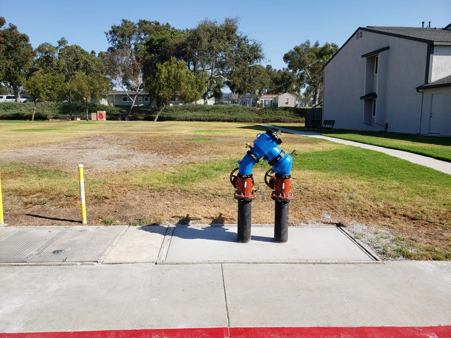 Above-grade backflow assembly over finished concrete pad, prior field experience